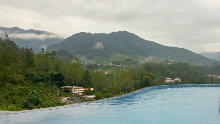Kolam air panas dengan latar perbukitan